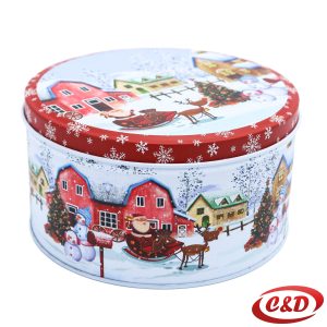 Okrugla metalna posuda s poklopcem, bijele boje s božićnim motivima kućica i crvenim kariranim detaljima.